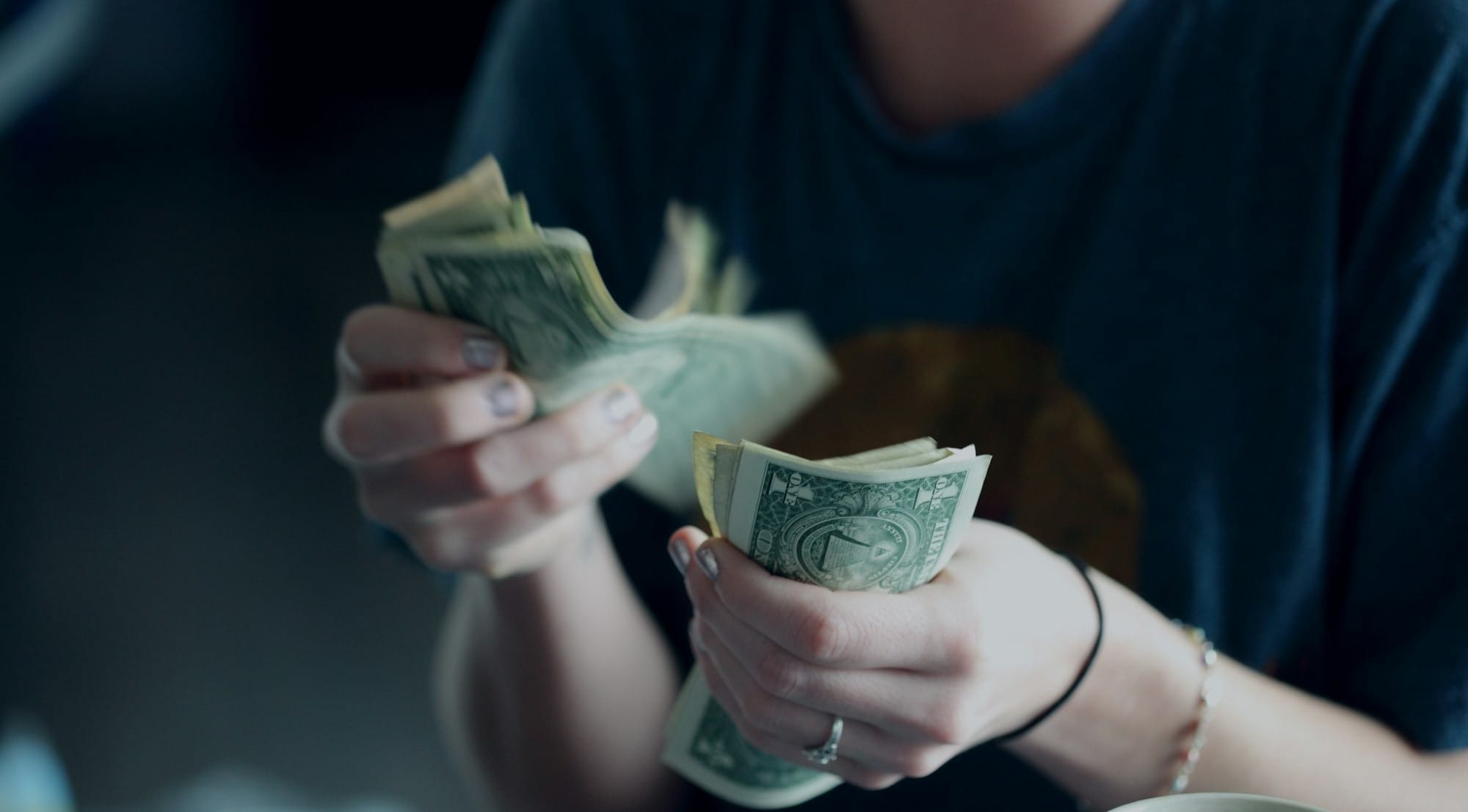 focus photography of person counting dollar banknotes