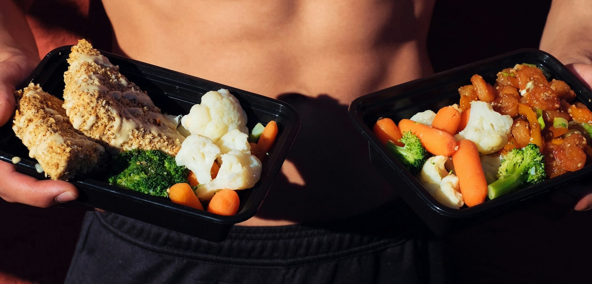 topless man in black shorts holding cooked food