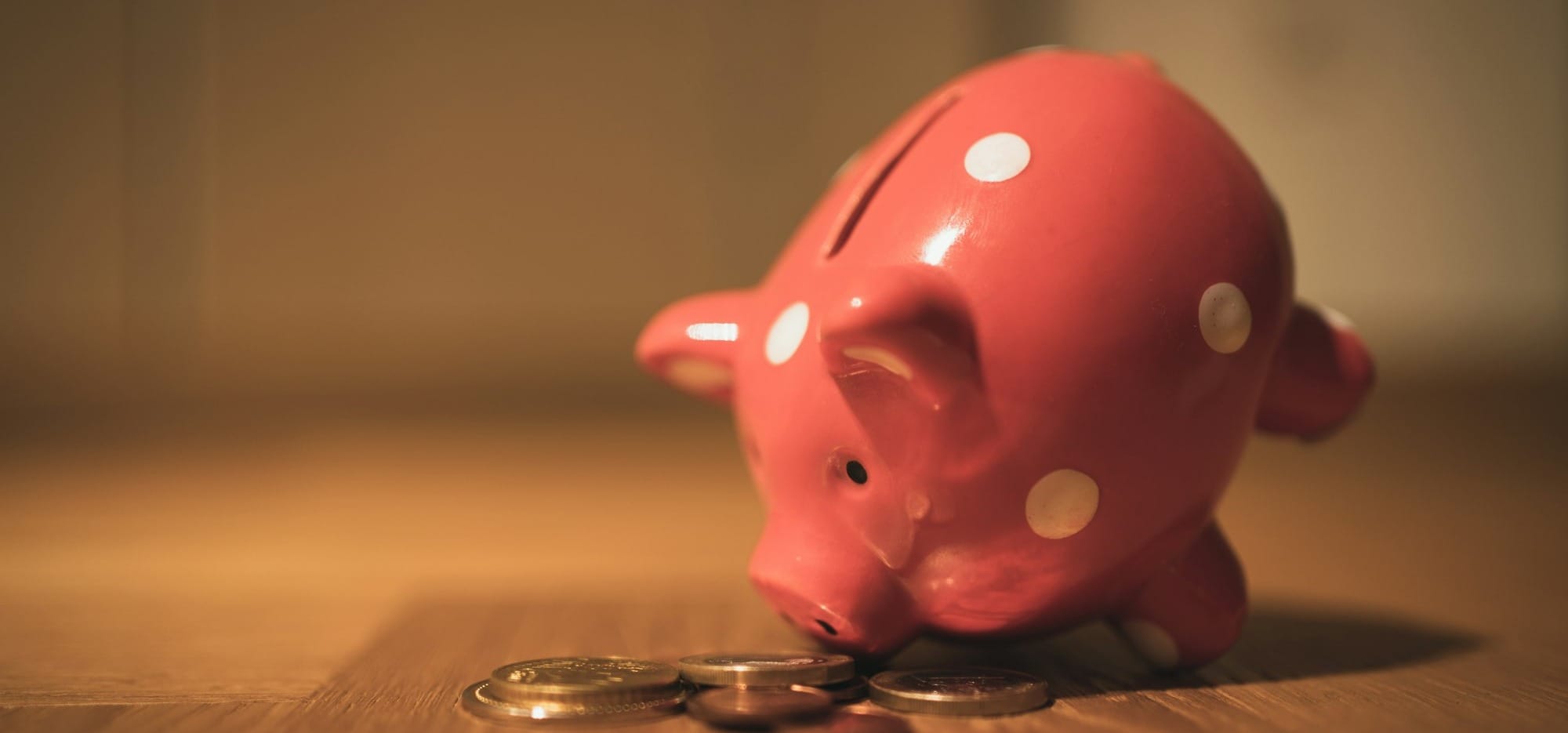 pink pig coin bank on brown wooden table